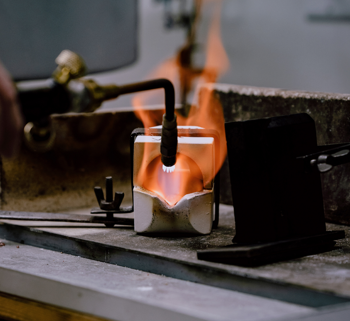 Flames appear from a crucible used to melt gold ready to be shaped into a custom piece of jewellery
